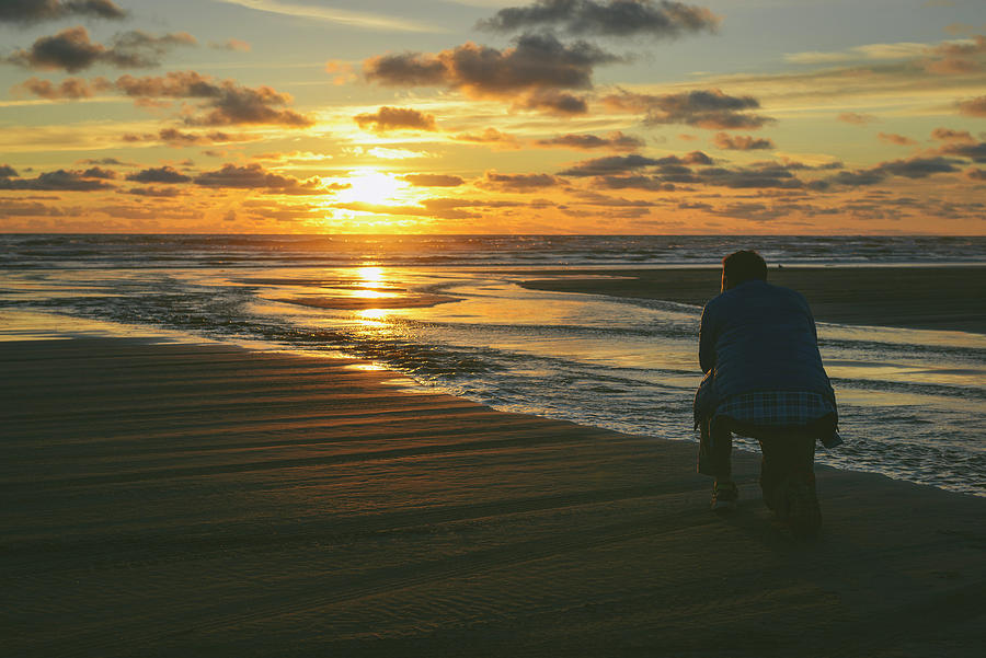 Rear View Of Hiker Kneeling At Long Beach During Sunset Photograph by ...