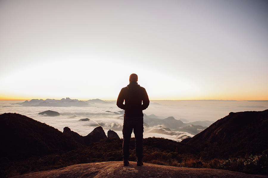 Rear View Of Man Standing On Mountain During Sunset Photograph by Cavan ...