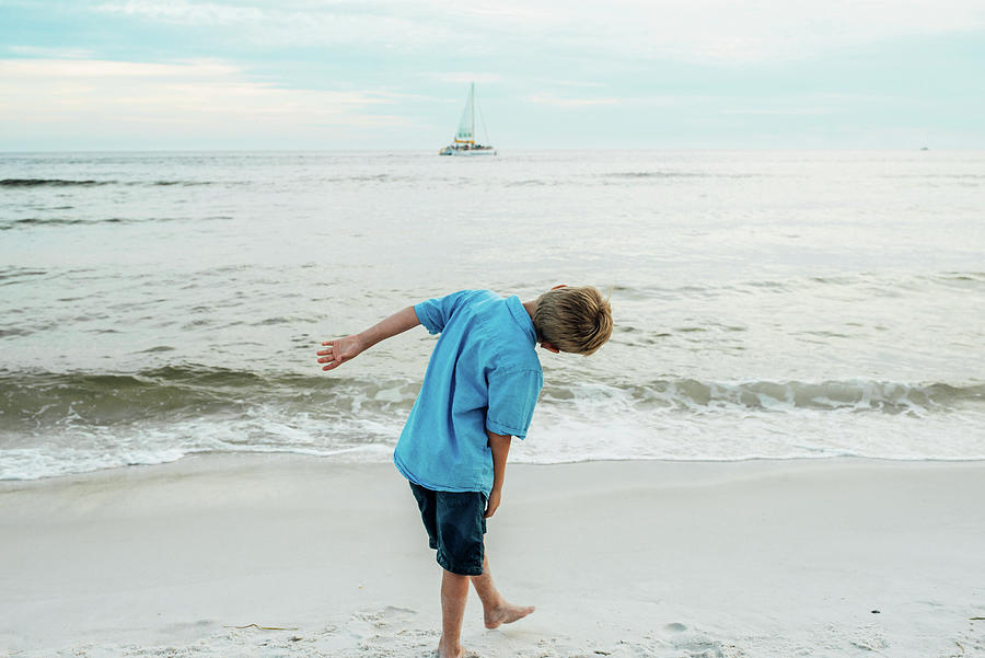 Nature Photograph - Rear View Of Playful Boy Bending At Panama City Beach Against Sky by Cavan Images