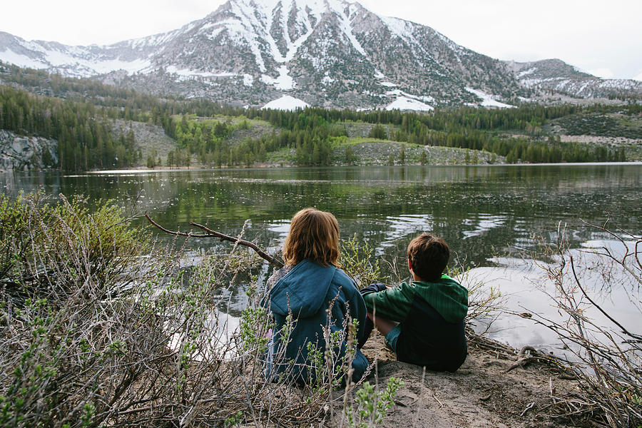 Mountain Photograph - Rear View Of Siblings Looking At View While Sitting By Lake At Inyo National Forest by Cavan Images