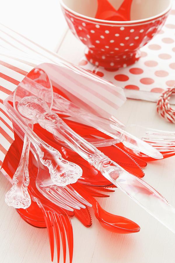Red And Transparent Plastic Cutlery For A Childs Birthday Party Photograph by Regina Hippel