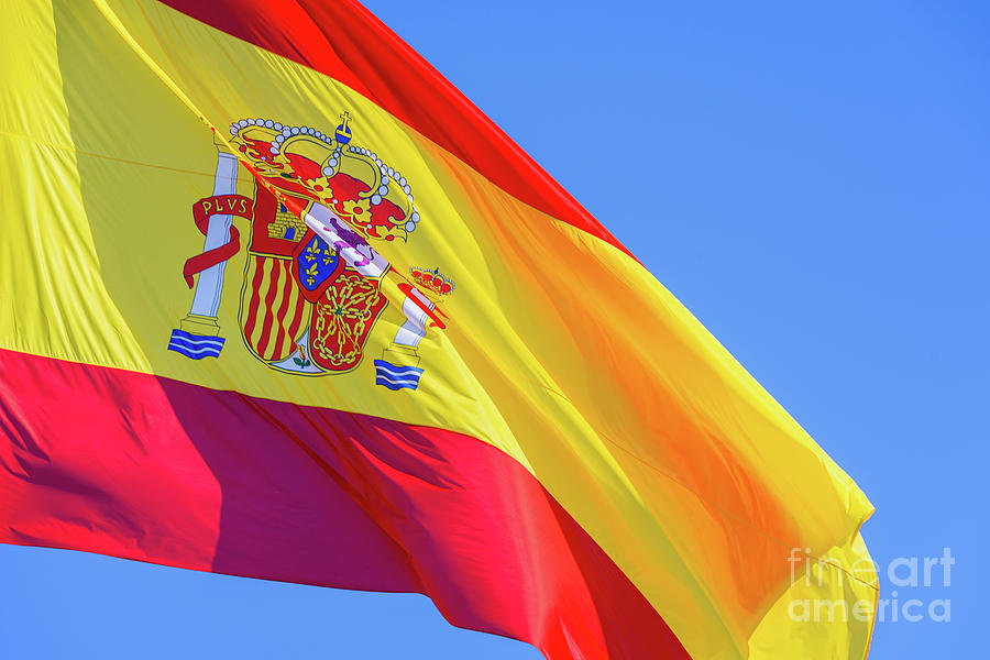 Red and yellow Spain flag with royal shield waving in the wind i Photograph by Joaquin Corbalan