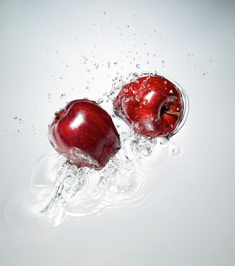 Red Apple Splashing In To Water Photograph by Chris Stein