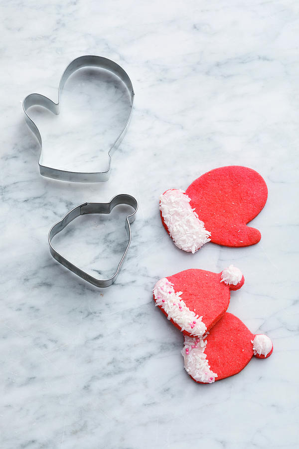 Red Biscuits And Biscuit Cutters In The Shape Of Hats And Gloves Photograph by Mathias Stockfood Studios / Neubauer