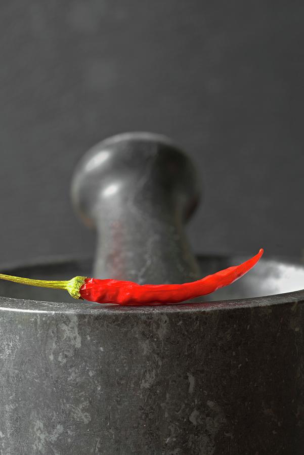 Red Chilli Pepper On A Mortar Photograph by Dr. Martin Baumgrtner