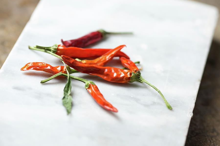 Red Chilli Peppers On A White Platter Photograph by Riccardobruni