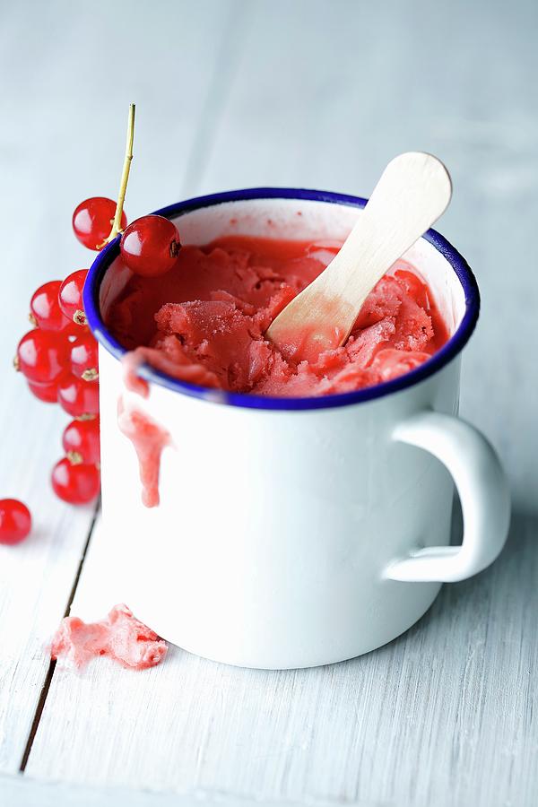Red Currant Sorbet In An Enamel Cup With A Wooden Spoon And Some Fresh Currants Photograph by Mona Binner Photographie