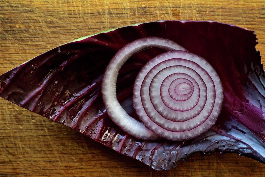 Red, Cut Onion On A Red Cabbage Leaf On Rustic Cutting Board Photograph by Andre Baranowski