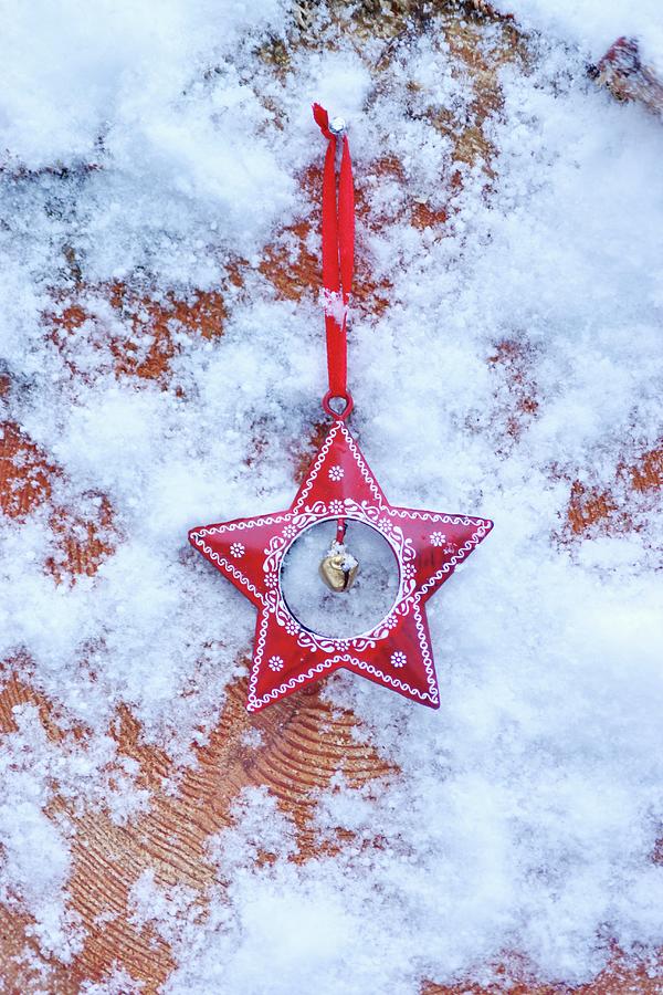 Red, Festive Star With Artificial Snow On Cross-grained Wood Photograph by Angelica Linnhoff