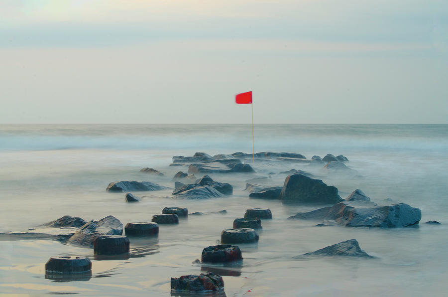 Red Flag on a Jetti - Stone Harbor New Jersey Photograph by Bill Cannon