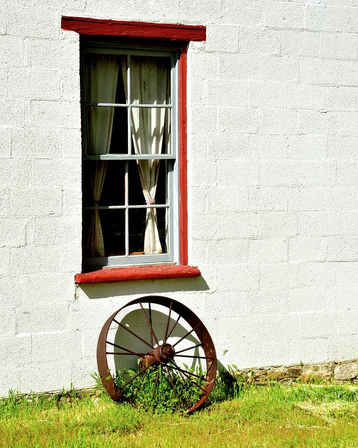 Red Framed Window And Wagon Wheel Photograph by Jerry Sodorff