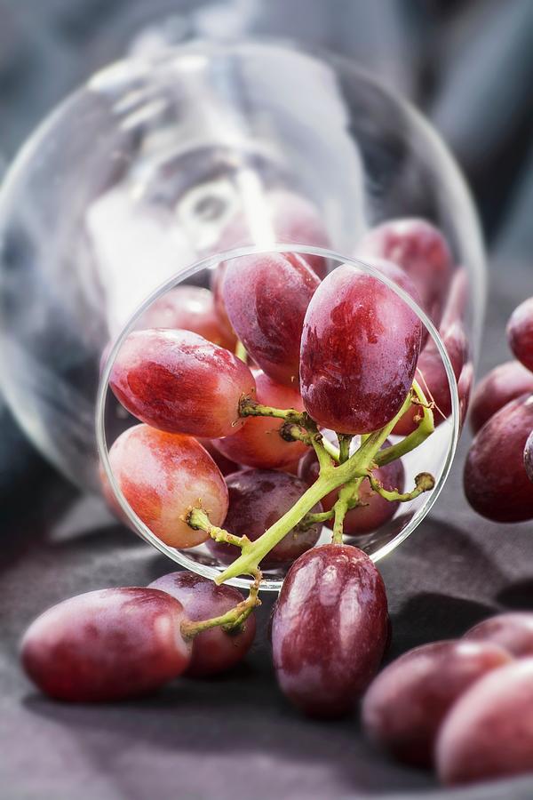 Red Grapes In An Overturned Wine Glass Photograph by Chris Schfer