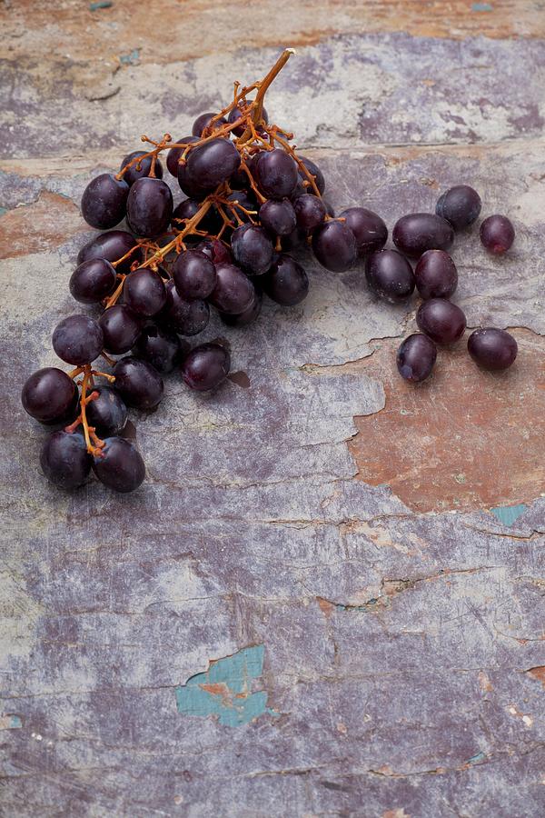 Red Grapes On A Weathered Surface Photograph by Studio Lipov