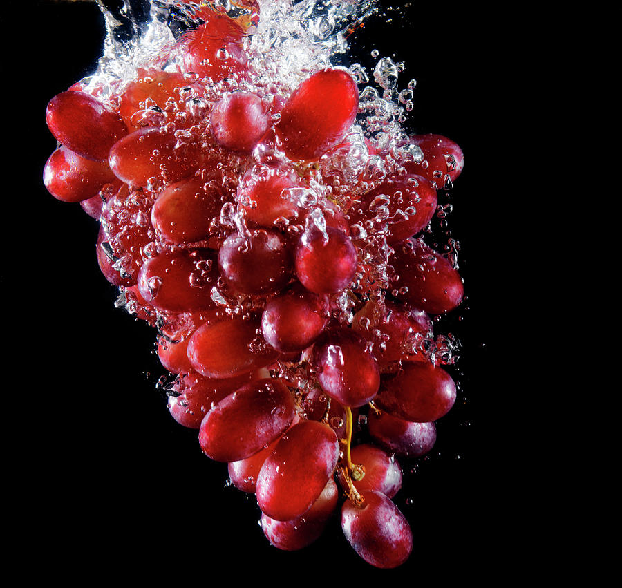 Red Grapes Sinking Into Water Photograph by Henrik Sorensen