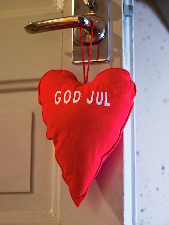 Red, Heart Shaped Pillow Hanging On A Door Photograph by Per Magnus Persson