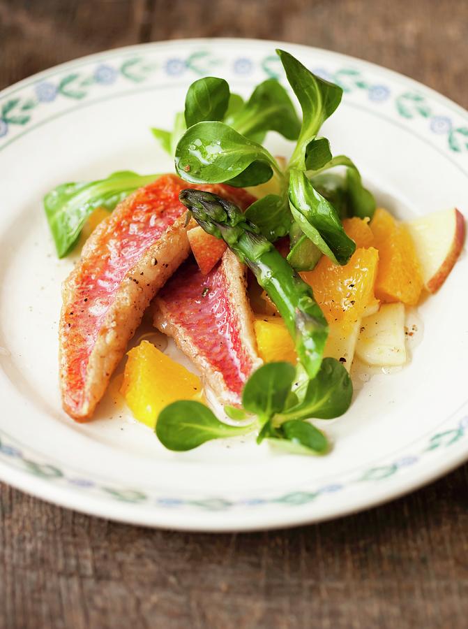 Red Mullet With Lambs Lettuce, Asparagus And Orange And Apple Pieces Photograph by Sporrer/skowronek