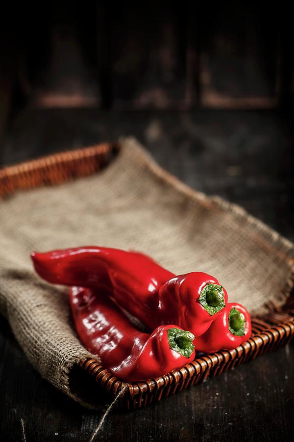 Red Pointed Peppers On A Cork Tray Photograph by Susan Brooks-dammann