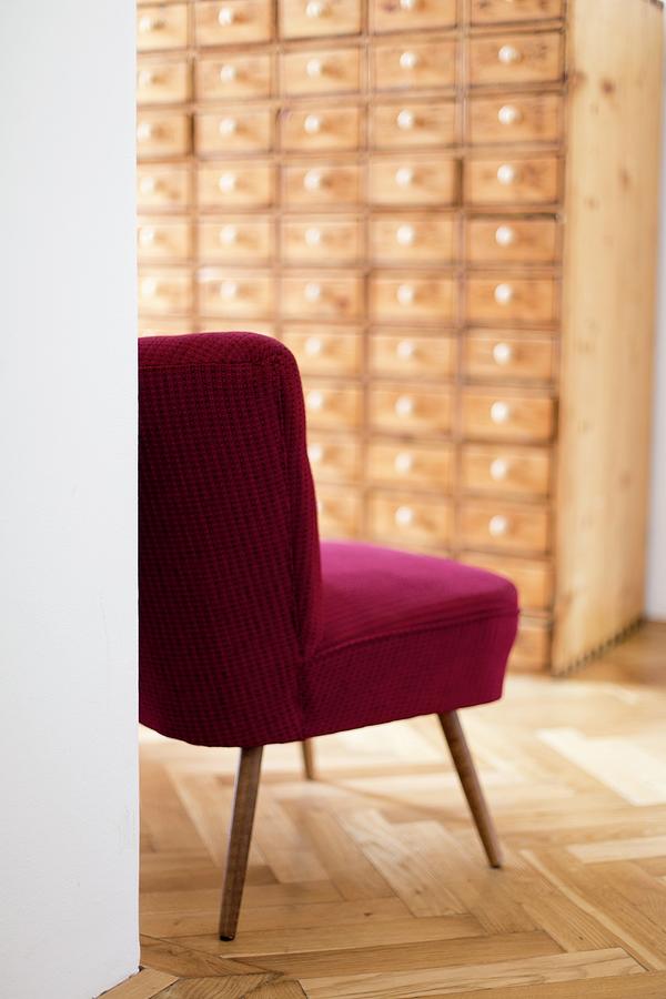 Red Retro Easy Chair In Hallway With Apothecary Cabinet Against Far Wall Photograph by Wiener Wohnsinn