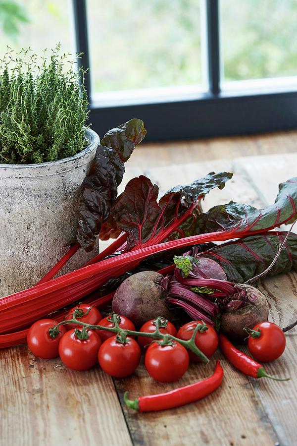 Red Vegetables On A Wooden Table In Front Of A Window Photograph by Misha Vetter