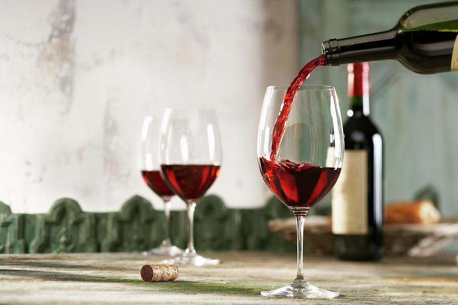 Red Wine Being Poured Into A Glass Photograph by Jalag / Peter Garten