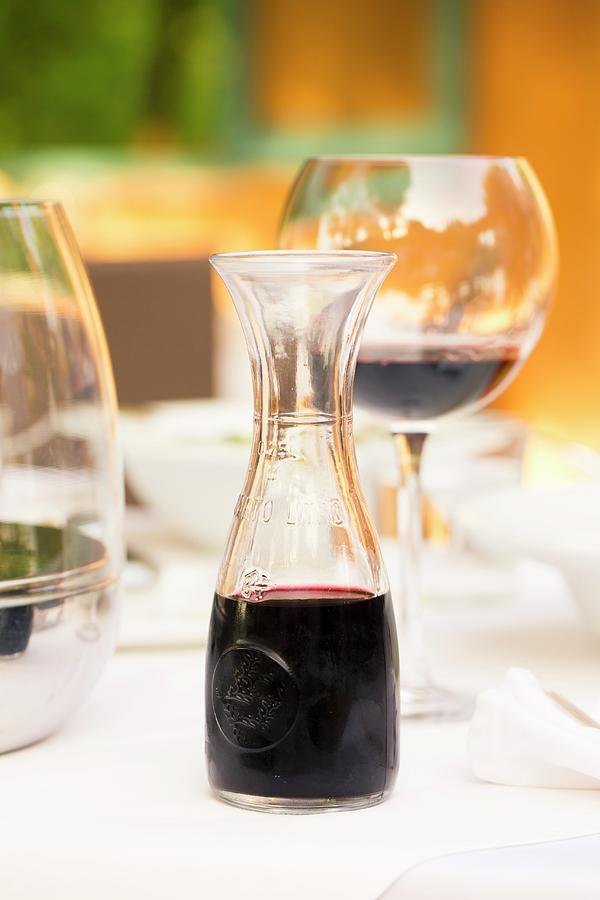 Red Wine In A Glass And A Carafe On A Laid Table Photograph by Esther Hildebrandt