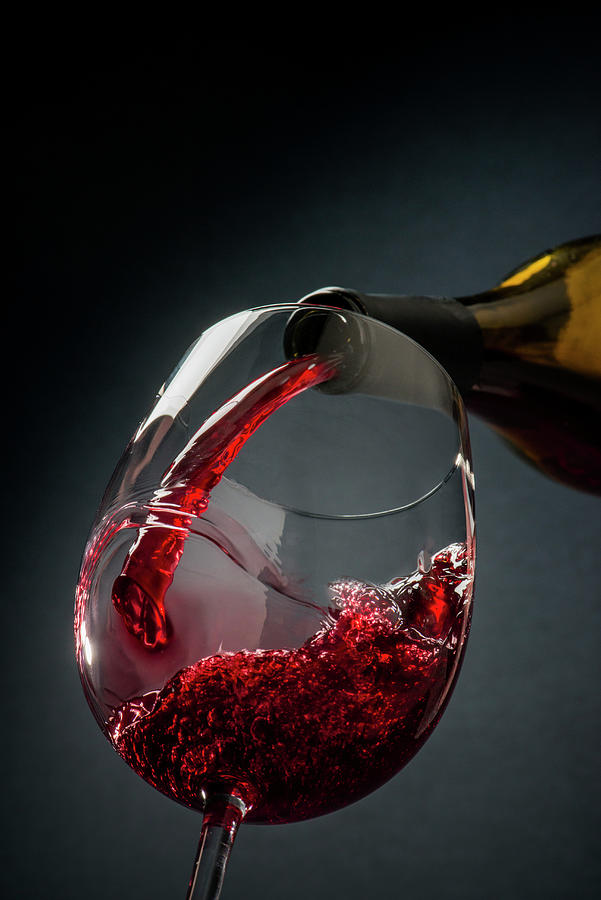 Red Wine Poured From A Bottle Into A Glass Photograph by Jim Scherer