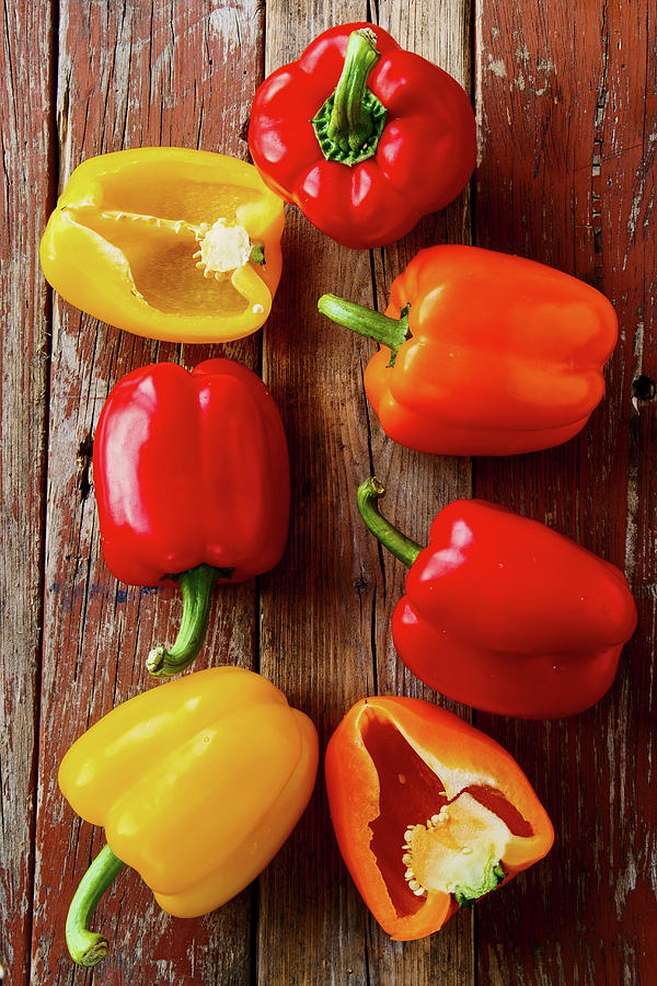 Red, Yellow And Orange Peppers On A Wooden Background Photograph by Yuliya Gontar