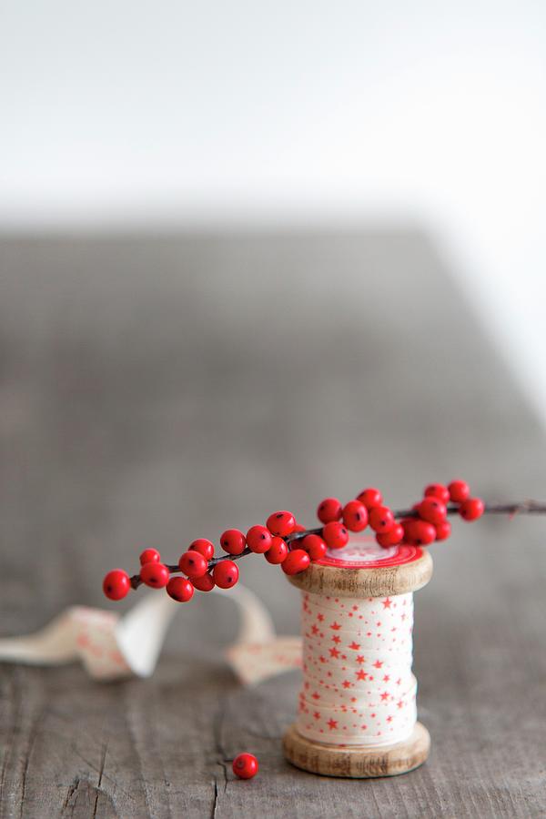 Reel Of Ribbon And Sprig Of Red Berries Photograph by Syl Loves