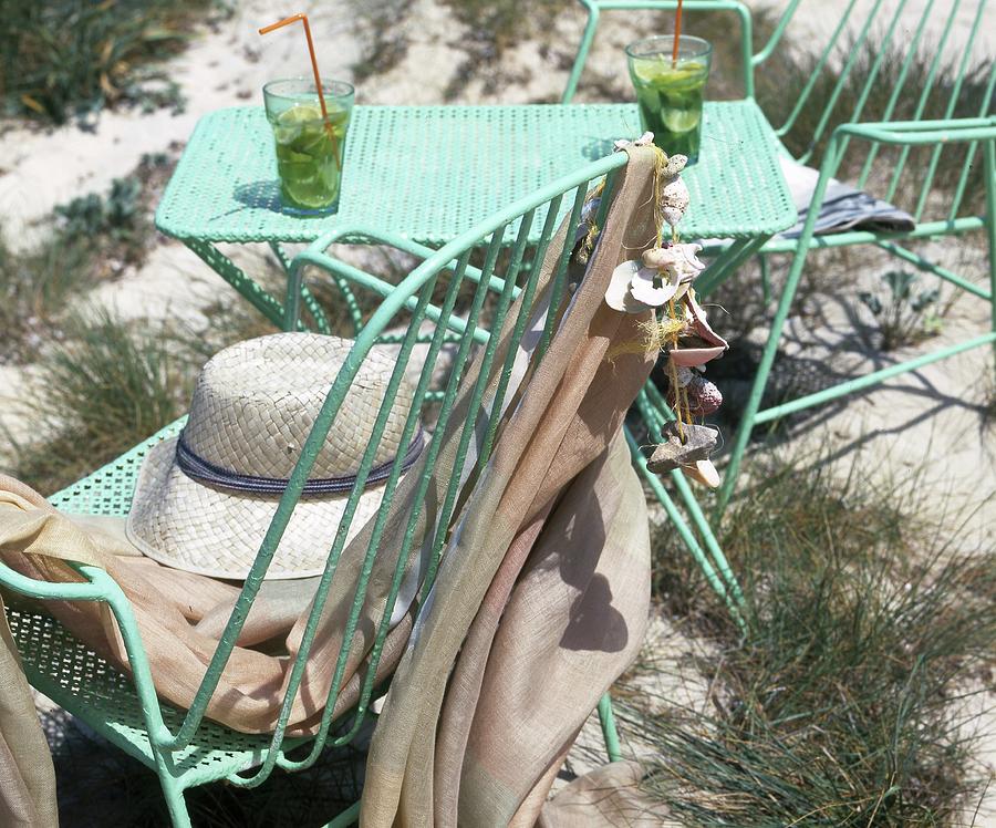Refreshing Drinks, Turquoise-painted, Metal Table With Matching Chairs And Sun Hat On Beach Photograph by Twins