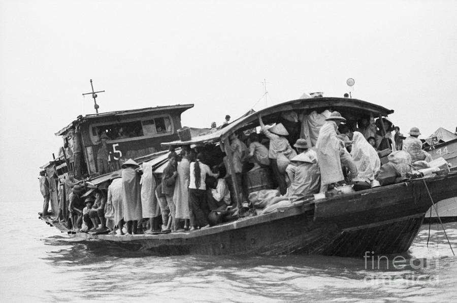 Refugees Huddled On Boat In Rain Downpou Photograph by Bettmann