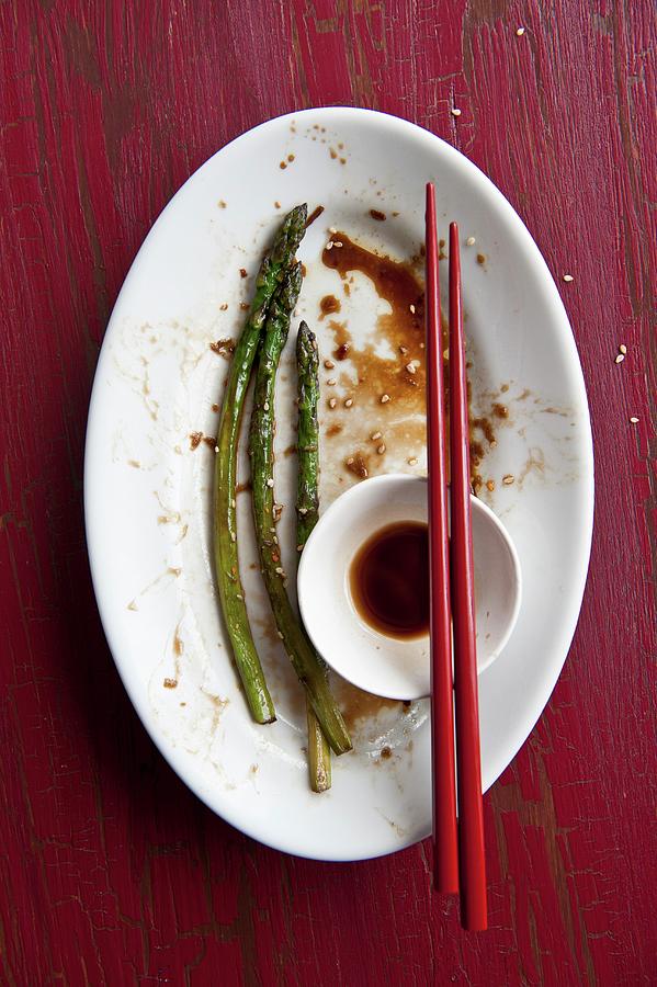Remains Of A Meal Of Fried Asparagus And Soy Sauce On A Plate With