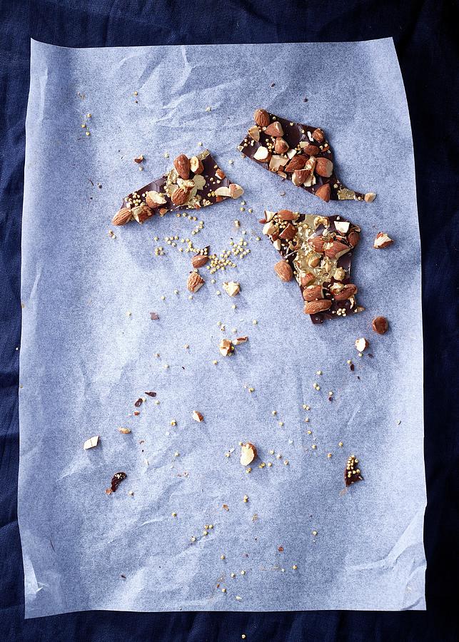 Remains Of Chocolate With Almonds, Sea Salt, And Roasted Millet On Baking Paper Photograph by Great Stock!