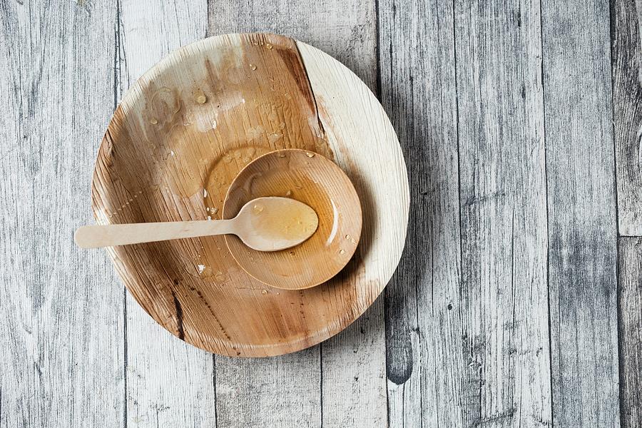 Remains Of Honey On A Wooden Plate With A Spoon Photograph by Mandy Reschke