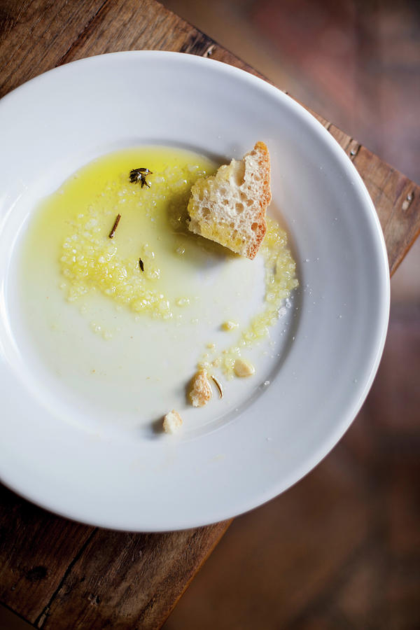 Remains Of Olive Oil And Bread On A Plate Photograph by Eising Studio
