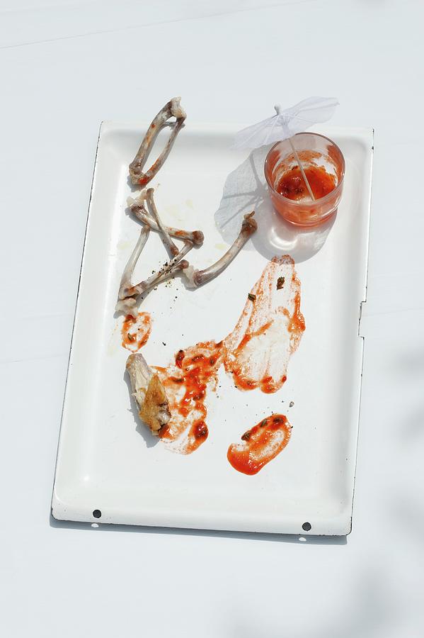Remnants Of Chicken Wings With Tomato Sauce On A Baking Tray Photograph by Gerlach, Hans