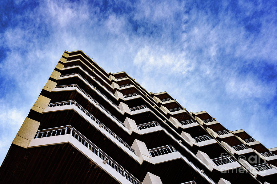Residential building of symmetrical architectural patterns with blue clouds background, real state concept. Photograph by Joaquin Corbalan