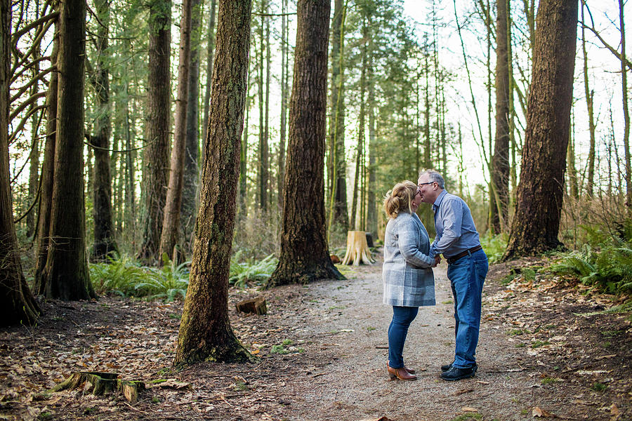 Nature Photograph - Retired Couple Kissing In The Woods. by Cavan Images