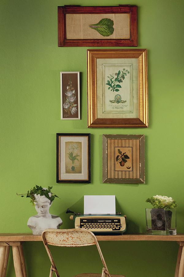 Retro Typewriter And Bust Below Framed Botanical Illustrations On Green Wall Photograph by Great Stock!