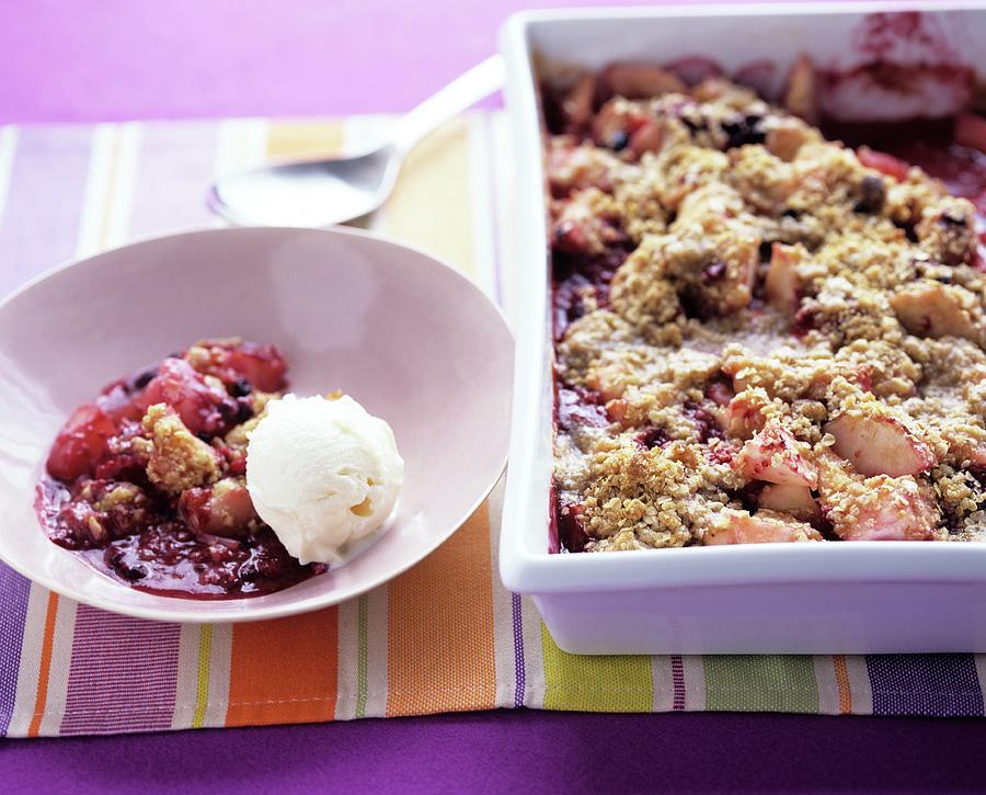 Rhubarb Crumble In A Baking Tin And On A Plate With Vanilla Ice Cream Photograph by Clive Streeter