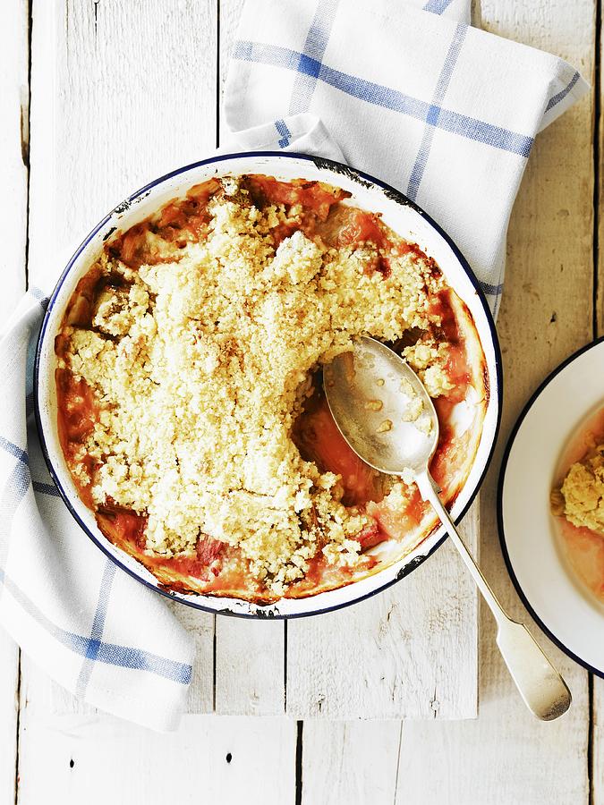 Rhubarb Crumble With Spoon In An Enamel Dish Photograph by Will Shaddock Photography