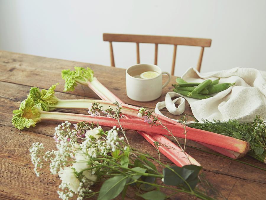 Rhubarb Stems And Flowers On A Wooden Table Photograph by Lukejalbert