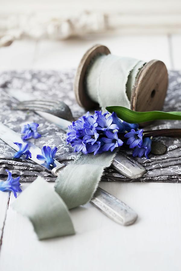 Ribbon On Wooden Reel, Cutlery And Hyacinths On Table Photograph by Martina Schindler