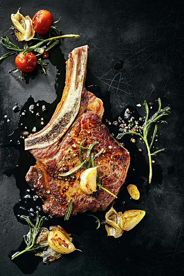 Ribeye Steak With Garlic And Rosemary Photograph by Manfred Rave
