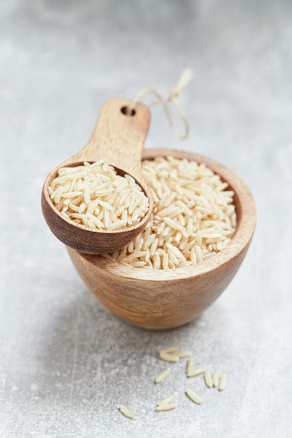 Rice In A Wooden Bowl And A Wooden Scoop Photograph by Brigitte Sporrer