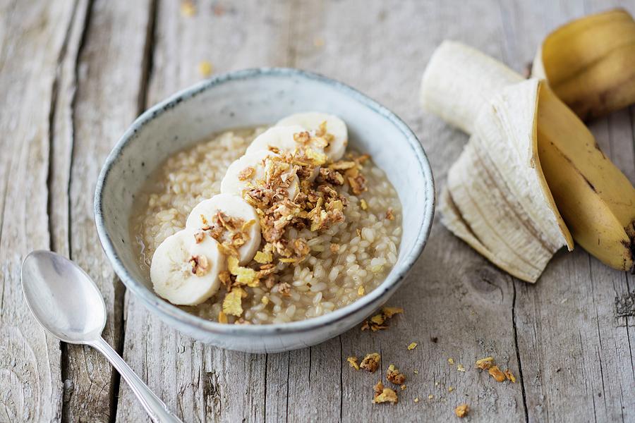 Rice Porridge Made With Lupin And Coconut Milk With Banana And Crunchy Flakes Photograph by Jan Wischnewski