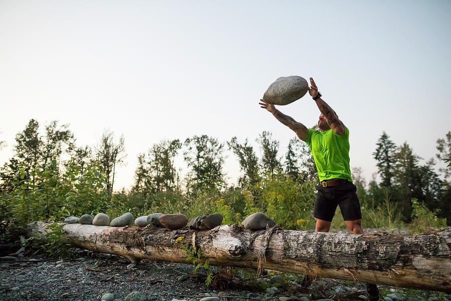 Ripped Man Throws Giant Boulder During An Outdoor Workout. Photograph