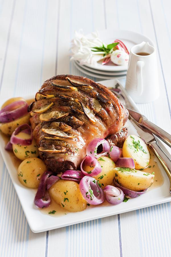 Roast Lamb Studded With Lemons On A Bed On Potatoes And Onions Photograph by Andrew Young