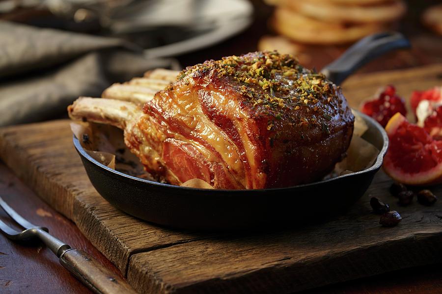 Roast Pork Roast In An Iron Pan On A Wooden Board With A Pomegranate Blood Oranges Photograph by Michael Pohuski