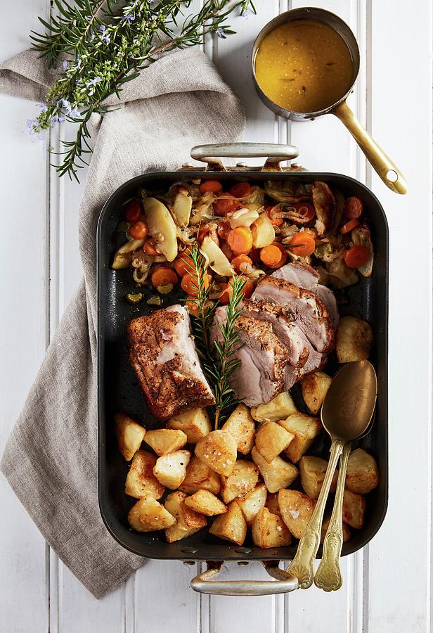 Roast Pork With Baked Potatoes, Apple, Vegetables And Cider Sauce Photograph by Great Stock!