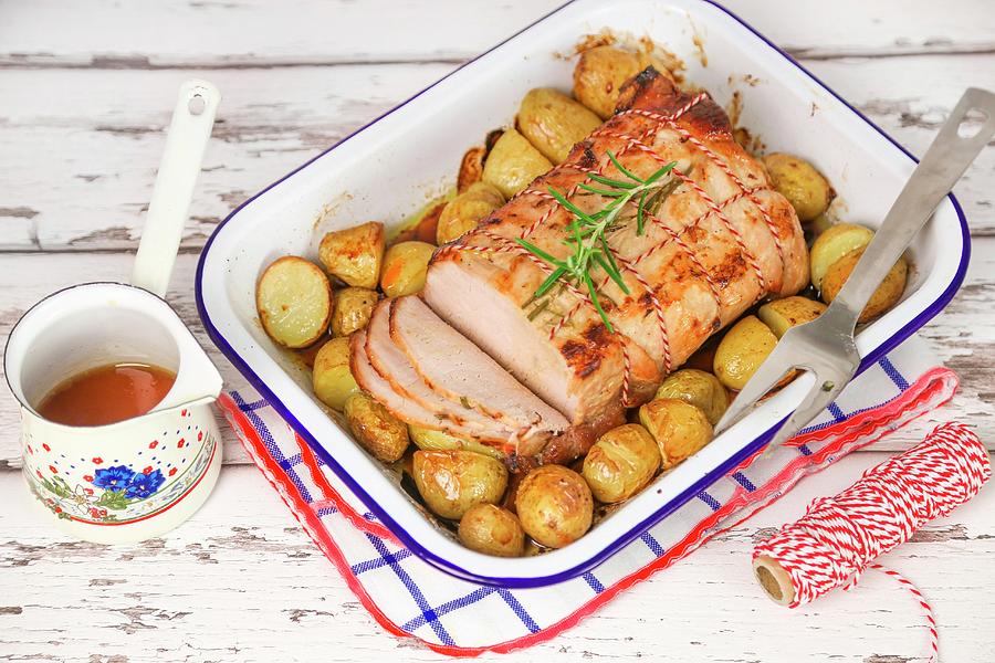 Roast Pork With Potatoes In A Roasting Dish Photograph by Claudia Gargioni